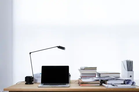 Escritorio con portátil, lámpara y libros