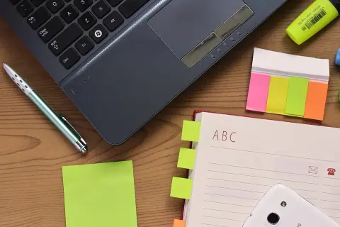 Portátil, cuaderno y bolígrafo sobre un escritorio